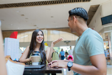 Happy mexican friends enjoying coffee and conversation at the shopping mall