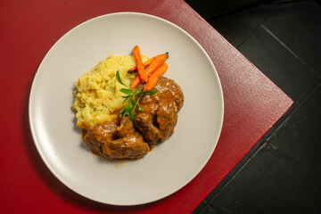 Stewed Iberian pork cheeks with creamy mashed potatoes, a tender and flavorful traditional dish from Spanish and Portuguese cuisine.