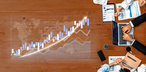 Professionals engaged in a business meeting analyzing stock market trends and financial data on...