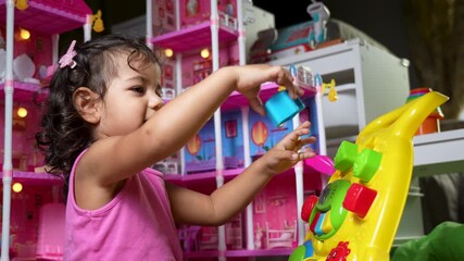 Toddler girl playing with colorful educational toy at home - Powered by Adobe
