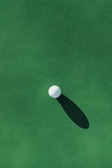 Golf Hole With Shadow of Ball and Flagstick on Green Turf During Bright Daylight