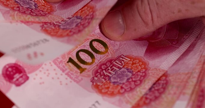 hold Chinese red money with a face value of 100 yuan, a beautiful background of money used in China close up
