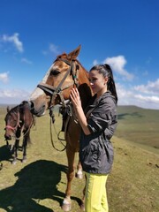 Obraz premium Young caucasian female with horses in scenic mountain landscape