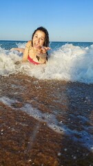 Young hispanic female enjoying waves on sunny beach day