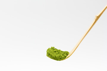 Cucharilla de bamb&uacute; con t&eacute; matcha en polvo sobre fondo blanco