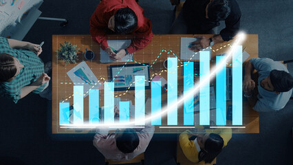 A team of professionals collaborates in an office setting, examining growth charts and data while brainstorming strategies for business development and success. Axiom