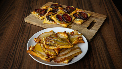 Figs and pears puff pastry tart on wooden table