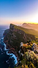 Dramatic coastal cliffs at sunset, rugged terrain meets ocean
