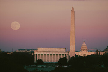 Full moon rising over Lincoln memorial, Washington monument and US Capitol building. 