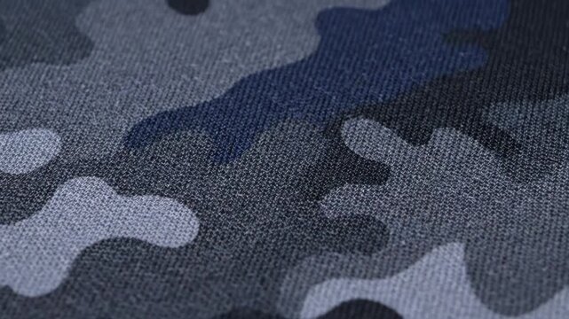 Urban Camouflage Fabric Texture - Close-up shot of a fabric with an urban camouflage pattern. The design features grey, blue and black tones creating a textured background.