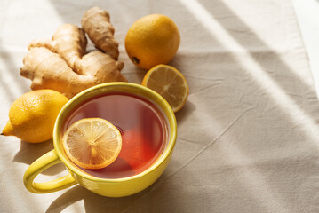 Flat Lay with Lemon Tea, Ginger and Honey on Light Table under Sun Light