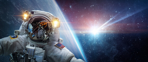 Astronaut in orbit of planet Earth against the background of a falling meteorite. Glowing comet,...