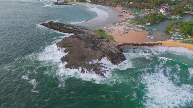Aerial Orbit Around Coastal Rocks and Fishing Harbor in Warm Evening Light