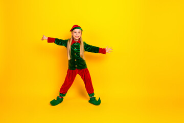 A cheerful child dressed as a festive elf spreading holiday cheer with bright colors against a vibrant yellow backdrop.