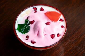 Faluda or Cold South Asian Dessert with Rose Ice Cream, Jelly, and Pomegranate in bowl side view of bangladeshi food