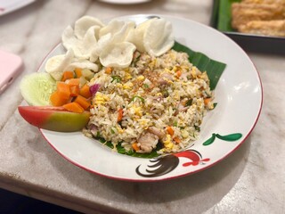 Traditional Indonesian fried rice (nasi goreng) served on a classic chicken-pattern plate with pickled vegetables (acar) and crispy crackers (kerupuk). October 1, 2025 - BSD, Indonesia