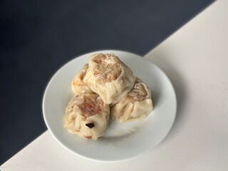 Three pieces of steamed dim sum served on a small white plate — a popular Asian appetizer made with chicken and shrimp filling, often found in dim sum restaurants. Karet, Indonesia - October 1, 2025
