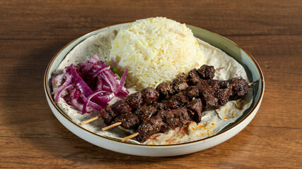 Lamb kebab with rice and lavash on plate