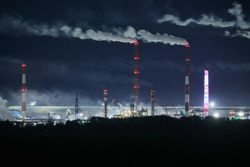 Night industrial landscape: smoke from factory chimneys. Environmental pollution.
