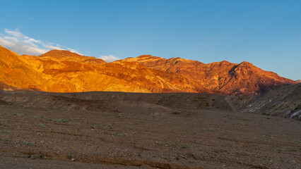 Golden Sunset on Mountains with Rocky Wash and Desert Plants, Death Valley National Park