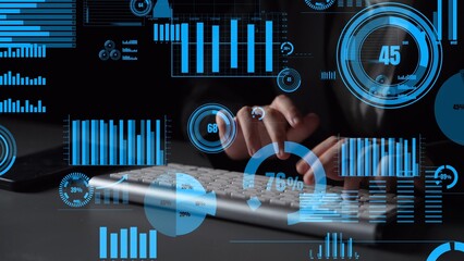 A professional environment showcasing data analysis trends with vibrant graphics and metrics while an individual works on a keyboard in a dark setting. Xenic