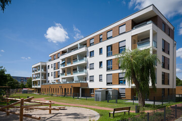 Modern apartment building with a playground in a green courtyard