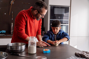 Family boys kneading dough on the kitchen counter at christmas holidays