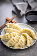 Traditional japanese gyoza dumplings and soy sauce on kitchen table.