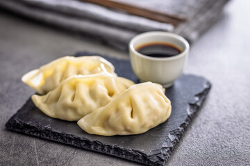 Traditional japanese gyoza dumplings and soy sauce on kitchen table.