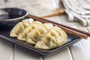 Traditional japanese gyoza dumplings on plate on white table.