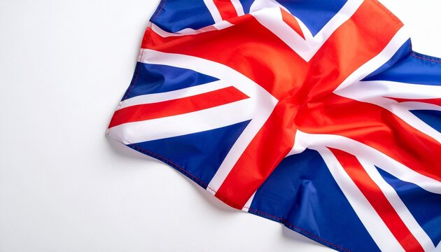 Partially spread Union Jack flag with red, white, and blue design incorporating crosses of St George, St Andrew, and St Patrick—laid on white background