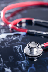 Red stethoscope and mri scans showcasing medical diagnostics and healthcare tools, spinal column...