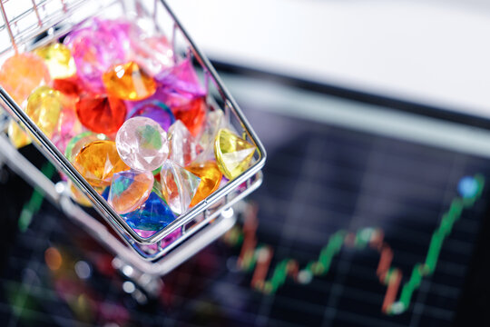 Assorted diamonds gems in shopping cart on stock market chart background - Powered by Adobe