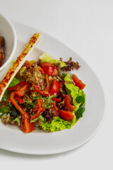 Green salad featuring vibrant fresh vegetables and breadstick