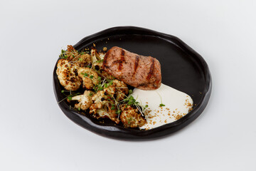Grilled pork tenderloin serving roasted cauliflower and cream