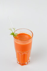 Fresh carrot juice in glass with straw