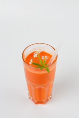 Carrot juice with flower garnish and drinking straw