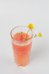 Refreshing pink drink with yellow flowers and straw