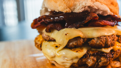 A massive and juicy double-patty burger, overflowing with crispy bacon and abundant melted cheese. This towering, indulgent creation is the ultimate comfort food, captured in all its delicious glory.