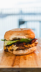 A perfectly grilled, juicy single-patty burger topped with crispy bacon, abundant melted cheese, and fresh green lettuce. A classic and delicious gourmet meal, captured in all its glory.
