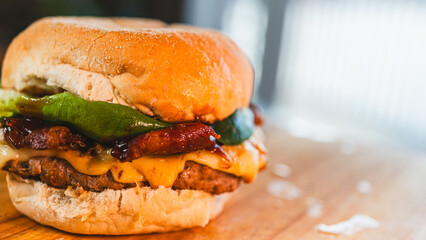 A perfectly grilled, juicy single-patty burger topped with crispy bacon, abundant melted cheese, and fresh green lettuce. A classic and delicious gourmet meal, captured in all its glory.