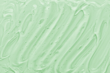 Aloe vera gel texture as a background. Green transparent cosmetic gel with bubbles.