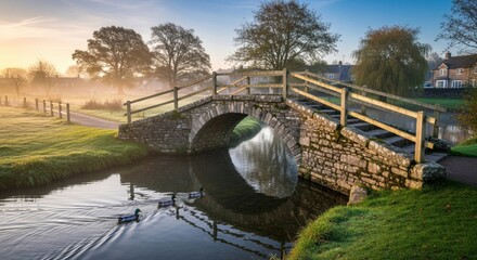 Dreamy Cotswolds village scene with quaint stone bridge, misty sunrise, and ducks swimming in the river, perfect for travel and lifestyle content