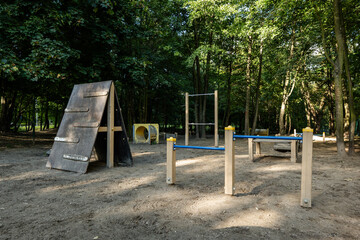Dog training area features agility equipment surrounded by lush greenery, providing a perfect environment for canine exercise and training
