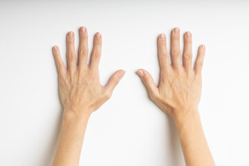 A pair of hands placed on a white surface with palms facing upward and fingers spread open. The lighting is soft and even, highlighting the natural lines and texture of the palms. The composition 
