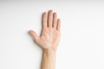 Naklejka premium Human hand with open fingers on a white background, top view.