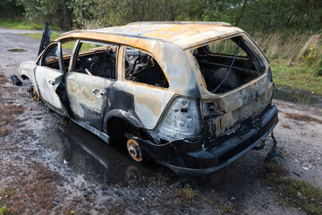Burnt-out car wreck. Road accident.

