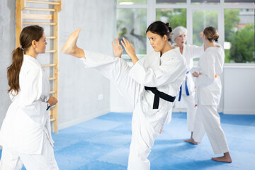 Two women are trained to perform basic defensive karate installations and attacking actions for...