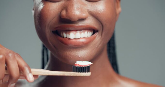 Dental health, toothbrush and mouth of black woman in studio with routine for fresh breath. Happy, toothpaste and African female person brushing teeth for oral care and hygiene by gray background.
