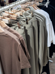 Mass market store display with various casual autumn and winter clothing items on hangers. Focus on affordable fashion and basic styles for everyday wear.